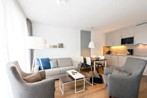 Wohn/Essbereich mit Couch, Sesseln, Esstisch und Küchenzeile