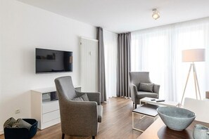 Wohn/Essbereich mit Sesseln, Esstisch und TV