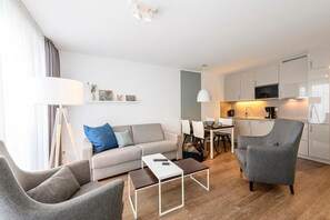 Wohn/Essbereich mit Sesseln, Couch, Esstisch und Küchenzeile