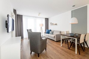 Wohn/Essbereich mit Sesseln, Couch, Esstisch und TV