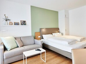 Wohn/Essbereich mit Couch und Doppelbett