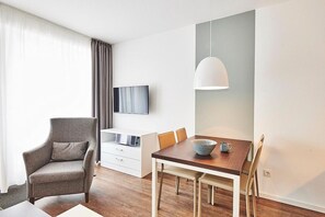 Wohn/Essbereich mit Sessel, TV und Esstisch