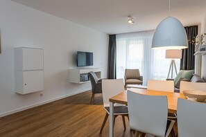 Wohn-Essbereich mit Esstisch, Sitzgelegenheit und Flatscreen TV