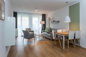 Wohn-Essbereich mit Couch, Esstisch, Sitzgelegenheit und Flatscreen TV