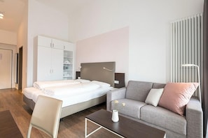 Wohn-Schlafbereich mit Doppelbett und TV
