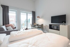 Wohn-Schlafbereich mit Doppelbett und TV