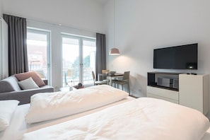 Wohn-Schlafbereich mit Doppelbett und TV