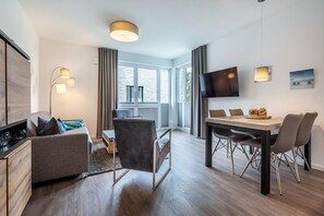 Wohn-/Essbereich mit Doppelschlafcouch, TV, Esstisch und Sitzgelegenheiten