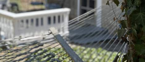 Relax on the hammock in the shade of the backyard. 