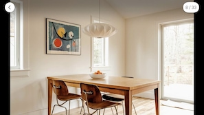 Johnny Poux Design signature dining table, looks out onto bucolic nature.
