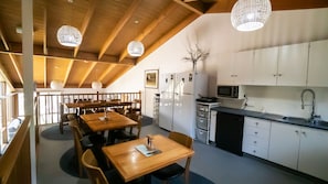 Shared dining & kitchen area with cathedral ceiling.