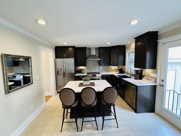 Well-appointed Chefs eat in kitchen with farmhouse sink, stainless appliances