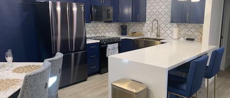 Kitchen with navy blue cabinets, gold fixtures