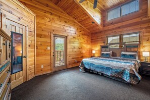 Main level bedroom with king-size bed offers access to the back deck with expansive mountain views.