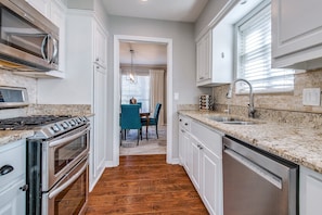 Kitchen with stainless steel appliances, gas oven, and granite countertops.