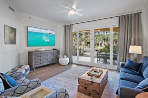 Living area with Large Smart TV - Sliding glass doors to your outdoor patio with access to the 8000 square foot pool and beach walkover.