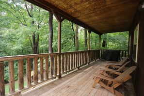 Covered porch with seating and a grill