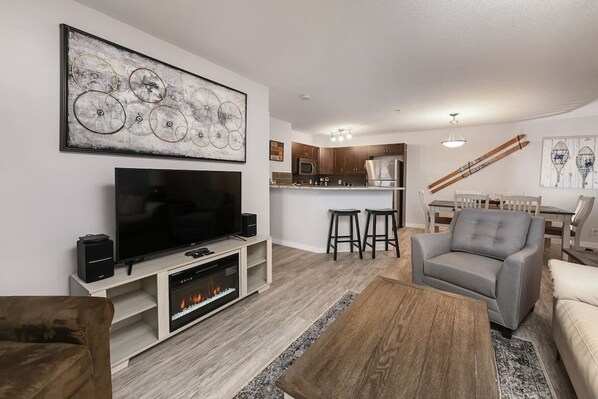 Living room with electric fireplace & smart TV & access to the oversized patio space.