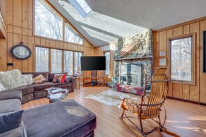 Spacious, rustic living room with a fire place and a table for 12