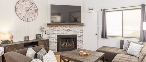 Living room with plenty of seating, gas fireplace and balcony