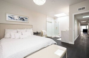 Master bedroom looking on to bathroom, with cal king bed.