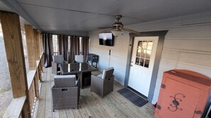 Screened in covered back porch area. Table with seating for 4 & 50" TV