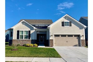 Front of the house. Neighboring house on one side. Open space on the other side.