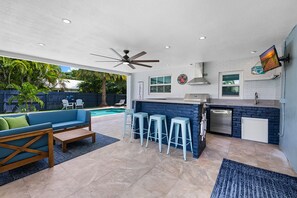 fantastic outdoor bar & kitchen with grill, mini fridge, sink, tv, & lounge area