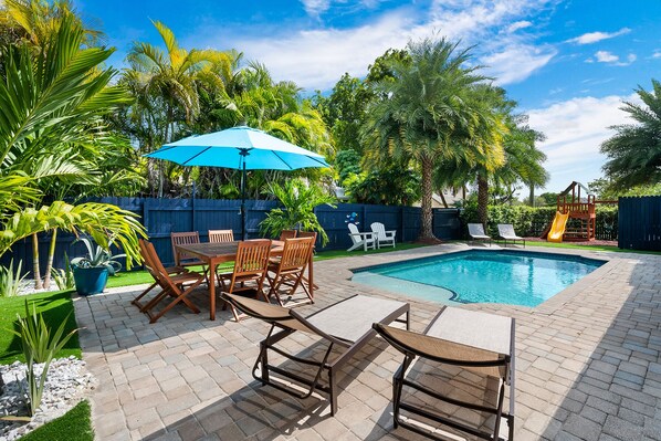 Truly breathtaking backyard with pool loungers and numerous hangout spots