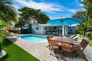 Stunning outdoor area with 8 seater table, heated pool, outdoor bar & playground