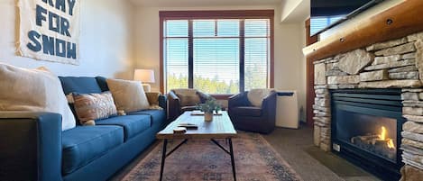 Bright living room with forest views and new carpets throughout!