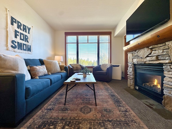 Bright living room with forest views and new carpets throughout!