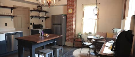 Fully stocked kitchen with original hardwood floors and exposed beams.