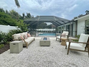 Lounging area with fire pit table in fenced-in backyard