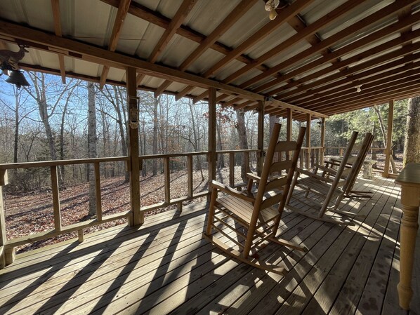 Large porch with rockers and table, overlooking the woods