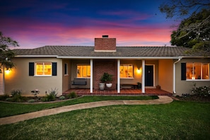 Large front patio seating area with lush grass in the yard.