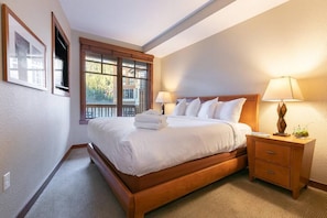 King bedroom with plush bedding and mountain views.