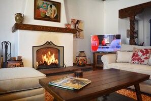 Enjoy the warmth of the wood burning fireplace  while watching the large flat screen TV.