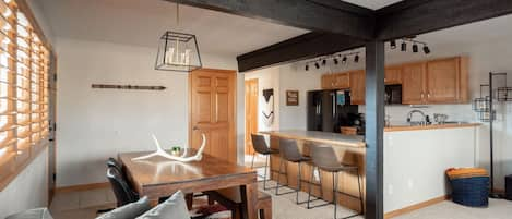 Dining area features a table and barstools