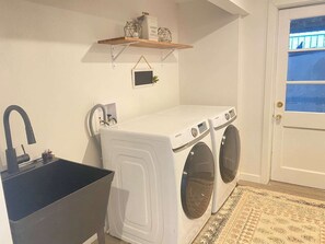 Laundry room with washer, dryer, and large sink.