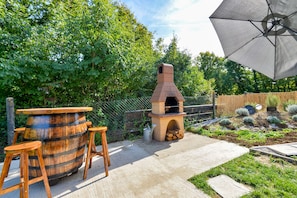 Brick grill with barrel table and wooden chairs