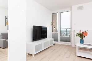 A minimalist media unit with a flat-screen TV, surrounded by natural light from large windows.
