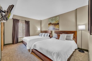 The home’s spacious second bedroom is perfect for sharing with two queen-size beds, a large closet, and an en suite bathroom.