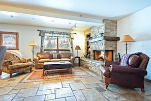 Relax in the living room with a comfortable leather sleeper sofa, armchair, indoor gas fireplace, and a flat-screen TV