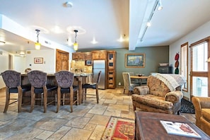 View of the dining area and fully-equipped kitchen with breakfast bar seating