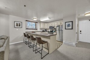 Kitchen: Drip coffee maker, blender, toaster, cooking utensils, tableware
