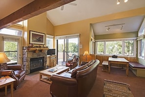 Family room with a leather sofa, lounge seating area, a flat-screen TV, and a warm indoor gas fireplace