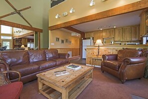 Family room with a leather sofa, lounge seating area, a flat-screen TV, and a warm indoor gas fireplace