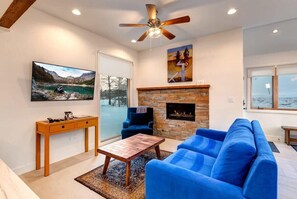 Relax in the family room with a plush sofa, armchair seating, a cozy indoor fireplace, and a flat-screen TV