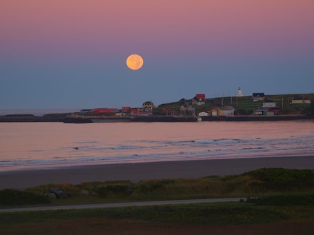 moon rise and sun sets behind the house